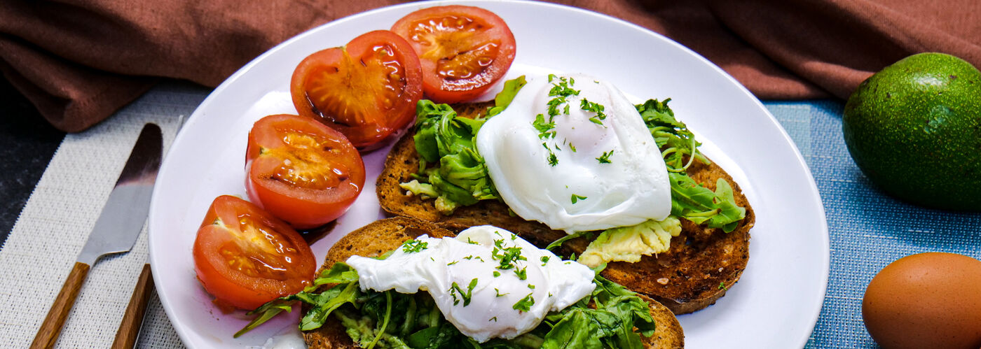 Poached eggs, avocado on toast with tomatoes 