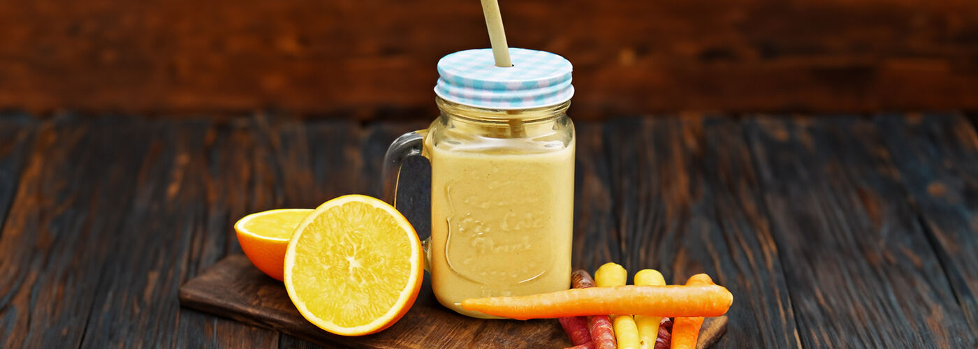 Carrot cake smoothie, carrots and an orange, halved