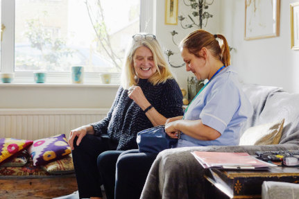Middle aged lady smiling with a friendly female healthworker