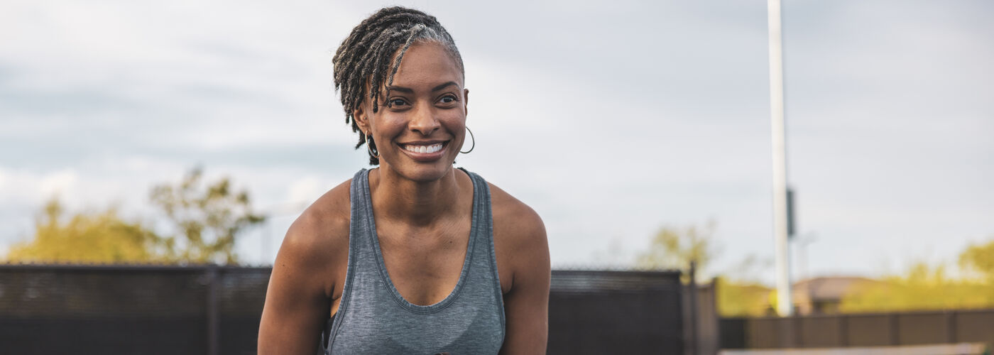 A smiling lady playing pickleball