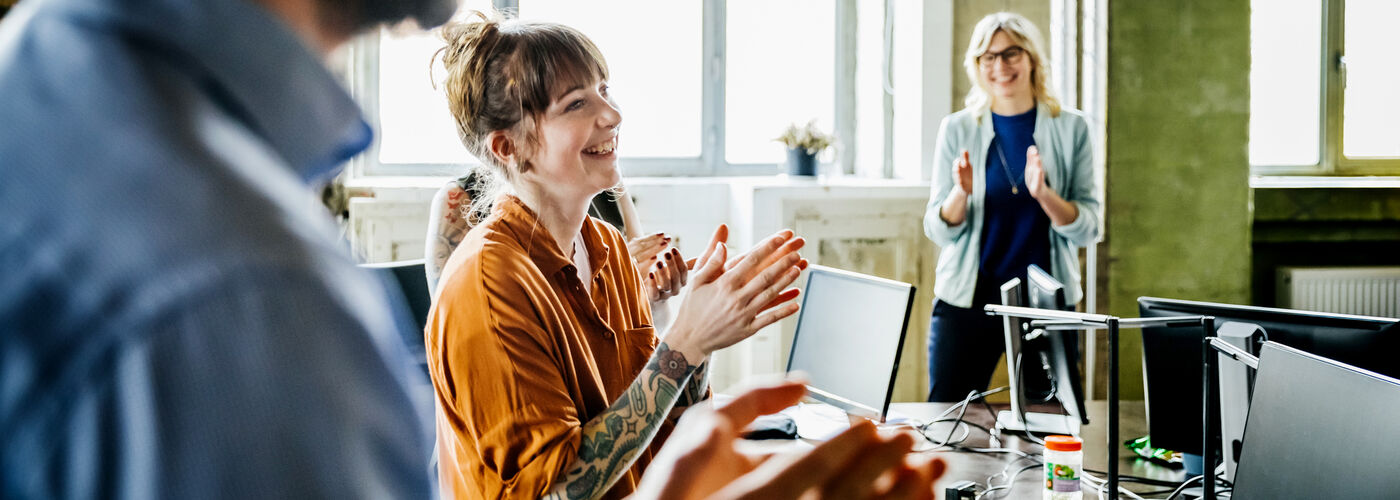 woman clapping and smiling in the office