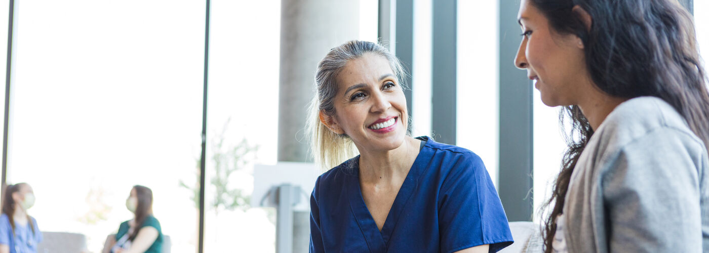 Doctor smiles as she listens to the patient