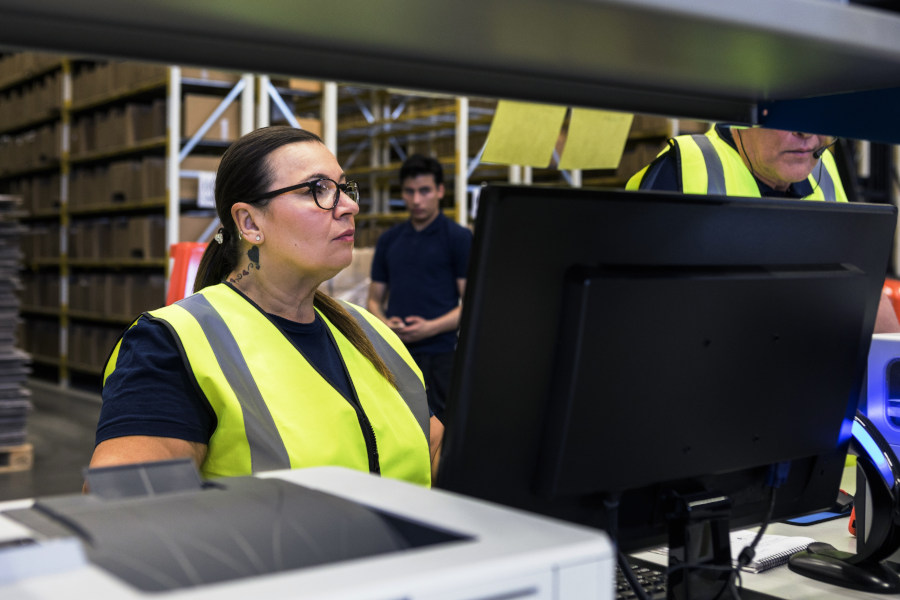 A lady with a colleague working in a warehouse