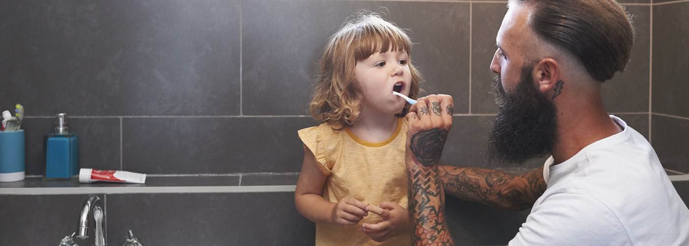Dad brushing daughter's teeth