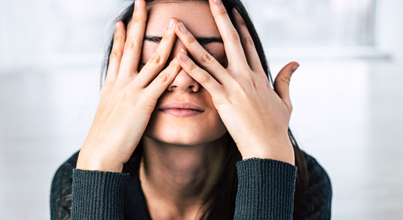 Woman with hands over her face
