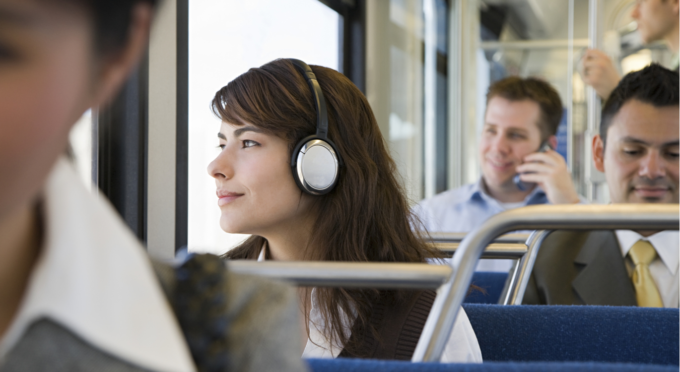 Woman listening to headphones on public transport