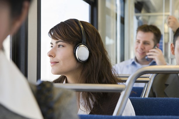 Woman listening to headphones on public transport