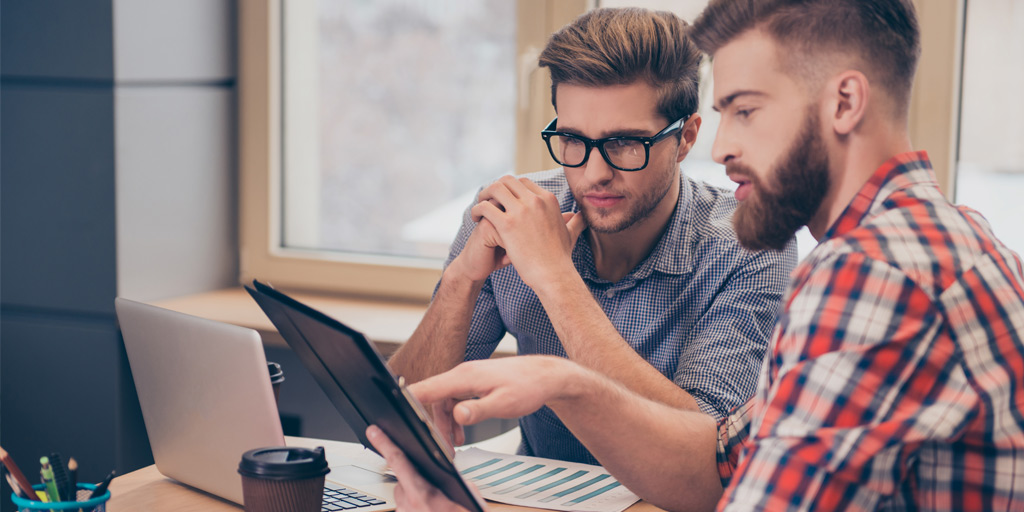 Two colleagues looking at a computer screen  