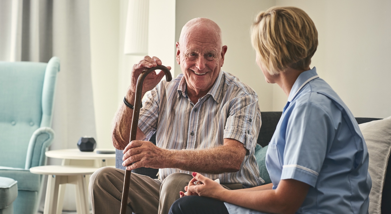 Elderly man with dementia chatting to a nurse 