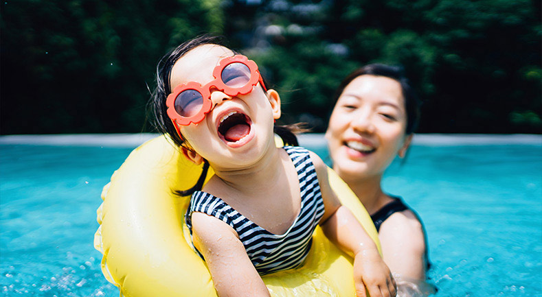 Mother and daughter having fun in a swimming pool