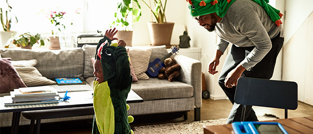 Dad playfully chasing young son in the home