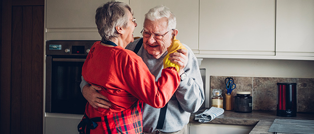 Older couple dancing together in the kitchen