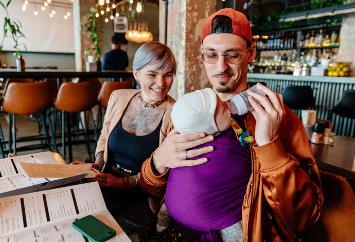 young father bottle feeding baby