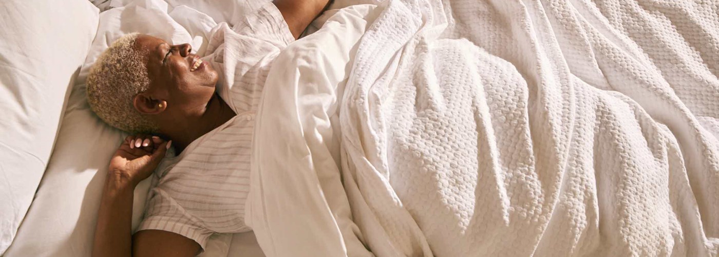 A woman in her 60s is happy waking up in the morning - she's had a good night's sleep without snoring