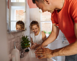 Father and daughter washing their hands