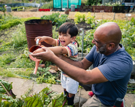 Father and young son watering the garden