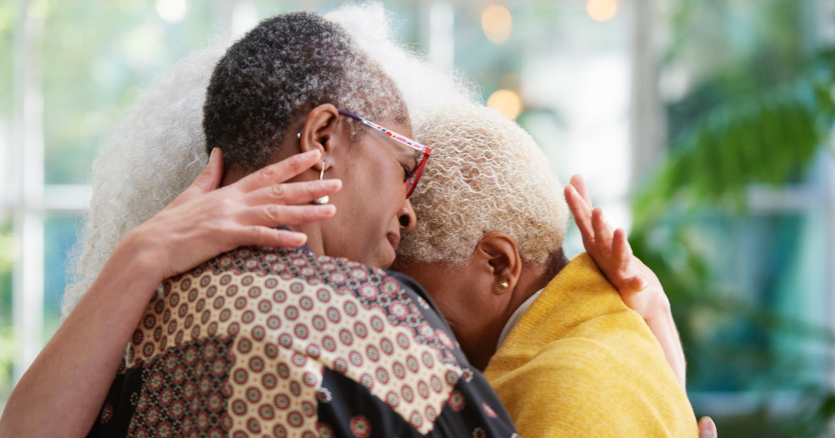 Three women are embracing, supporting each other
