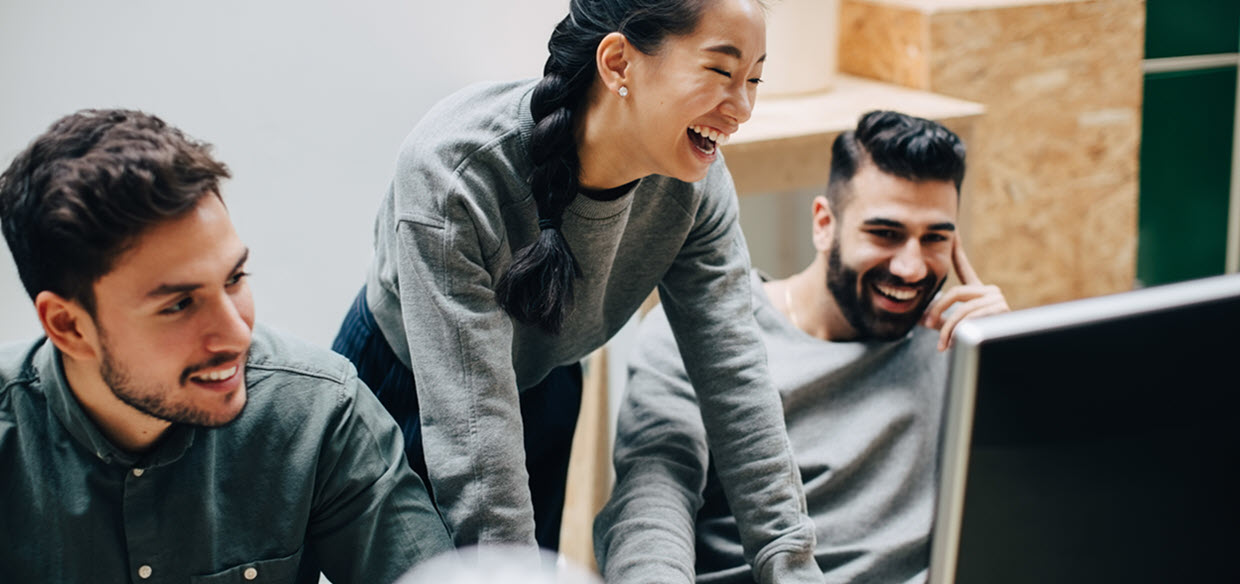 Group of young employees looking at work together