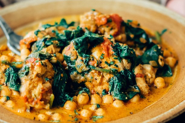 A grey bowl containing a vibrant spinach and chickpea curry 