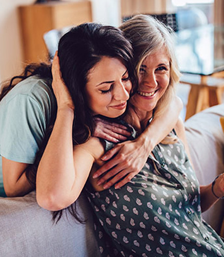 Mother and grown up daughter hugging