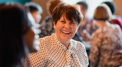 A lady smiling at a conference