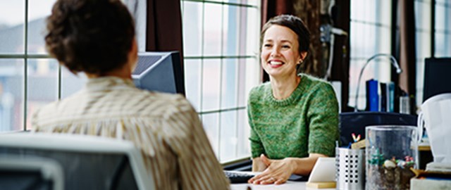 Smiling business owners at workstation in office