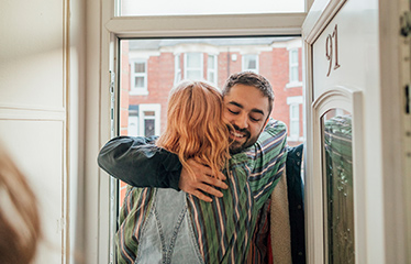 Man and woman hugging in a doorway 