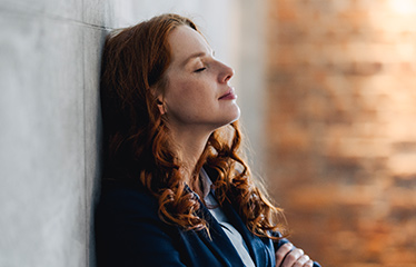 Woman resting against a wall 