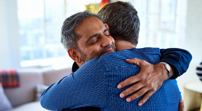 Two men embracing and smiling in relief