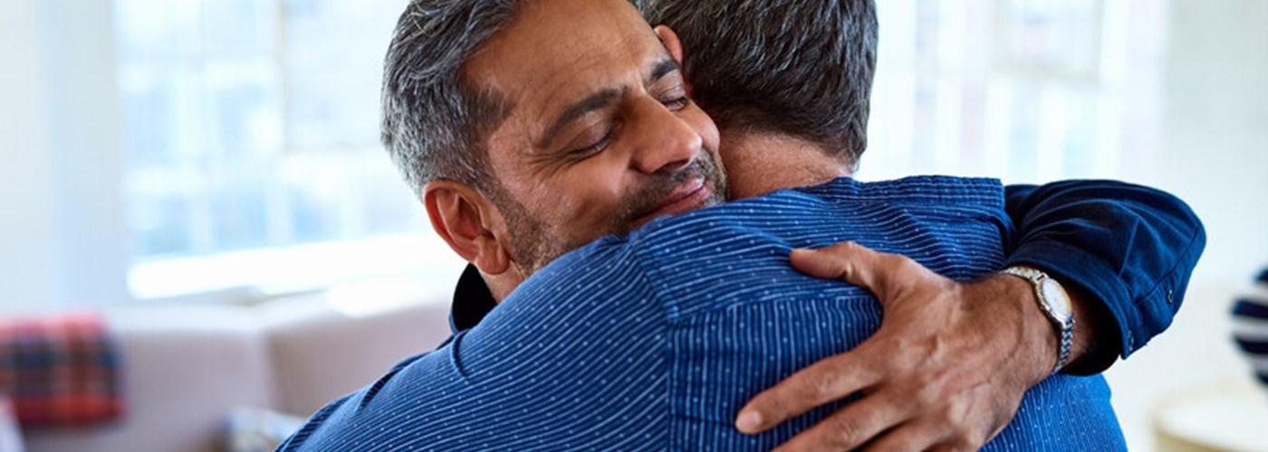 Two men embracing and smiling in relief