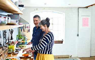 Man and woman in a kitchen cooking 