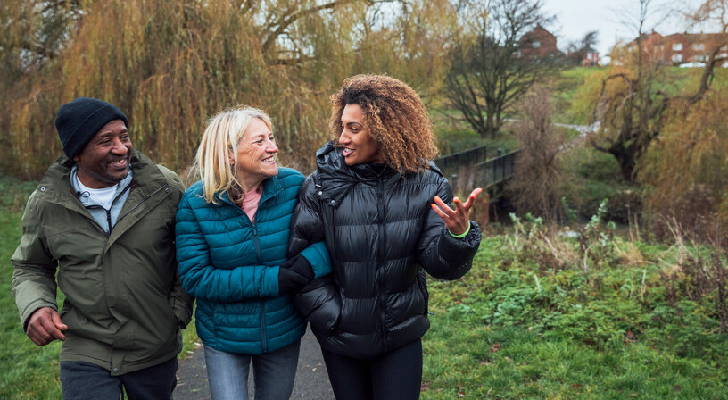 A family talking while taking a riverside walk