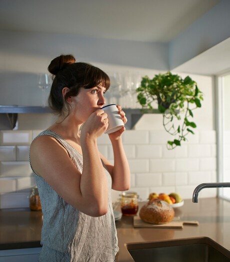 Woman drinking from mug in zero waste kitchen