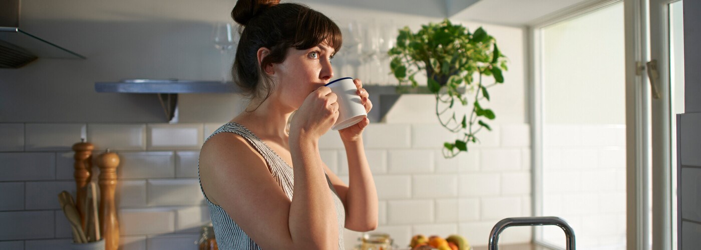 Woman drinking from mug in zero waste kitchen