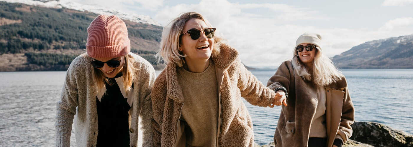 Three young women on brisk walk in the sunshine 