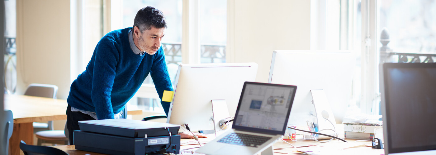 Man standing working at a desk in an office