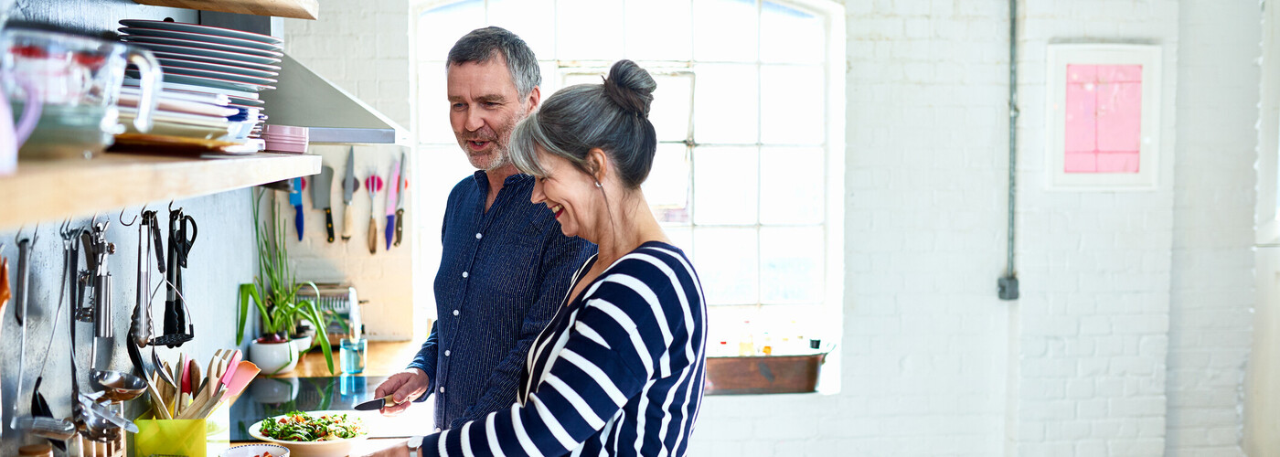 Mature couple preparing vegetarian meal in stylish kitchen