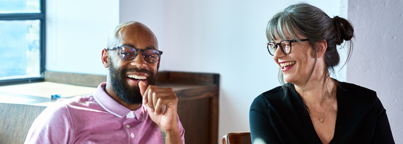 Cheerful businesswoman laughing with male coworker