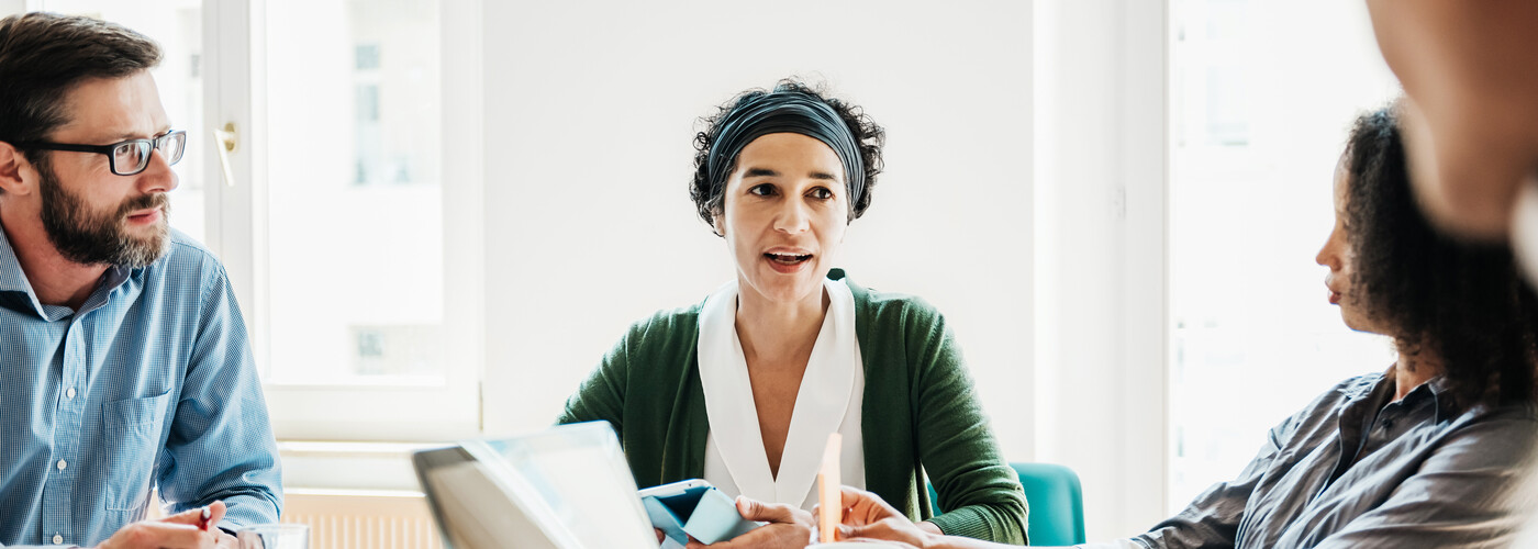 Female coworker working with colleagues around a table