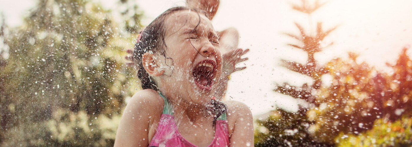 Little girl smiling, playing with water