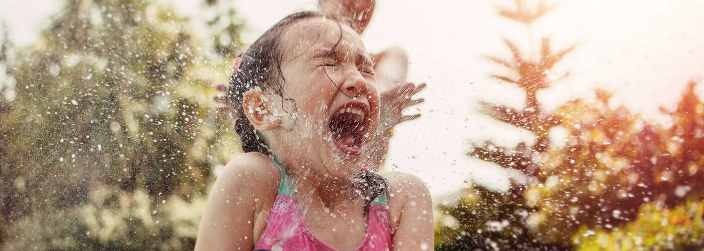 A girl playing with water on a sunny day