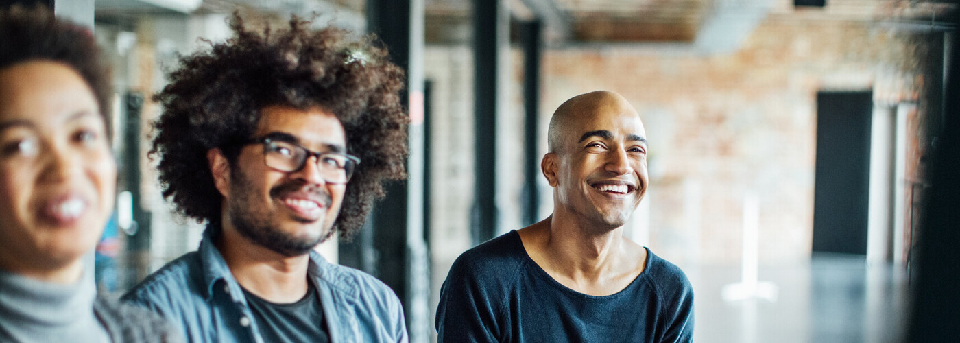 Smiling colleagues listening in meeting