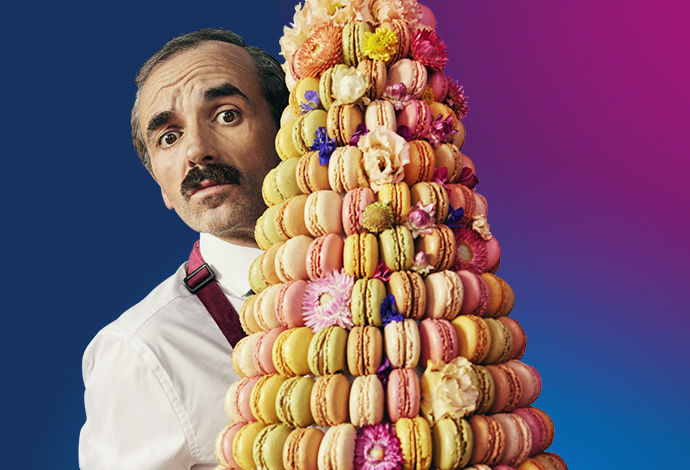 A server with a tray of macarons