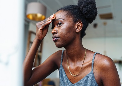 Young woman applying skin care on her face rosacea