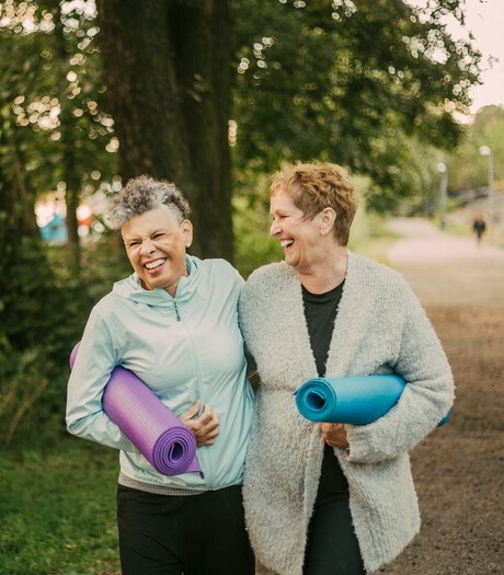 Women walking together holding yoga mats