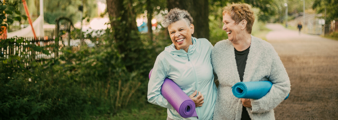 Women walking together holding yoga mats
