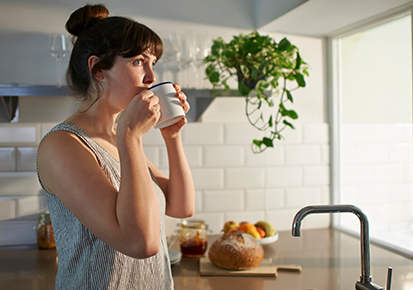 Woman drinking from mug in zero waste kitchen