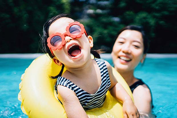 Travel insurance claims - Mother and toddler smiling in a swimming pool