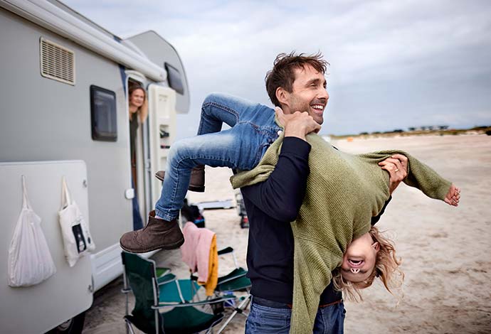A father playing with young son on the beach