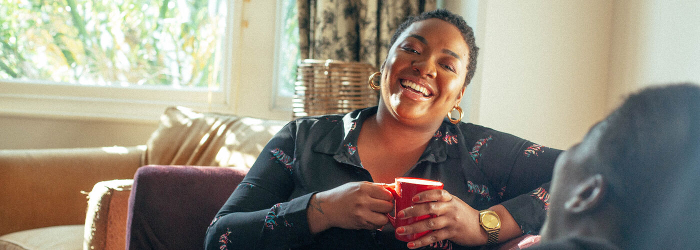woman sat on the sofa, laughing
